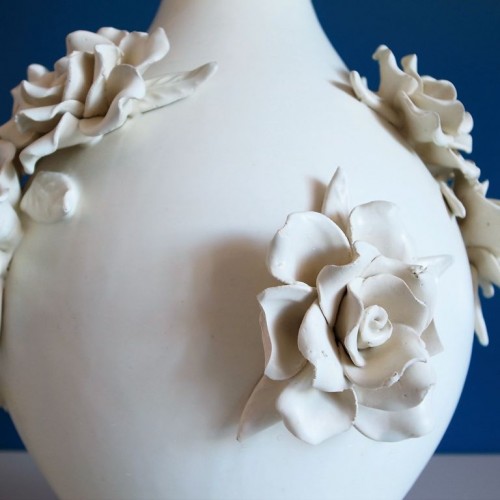 Original y elegante diseño en forma de jarrón con aplicaciones de racimos de flores y hojas