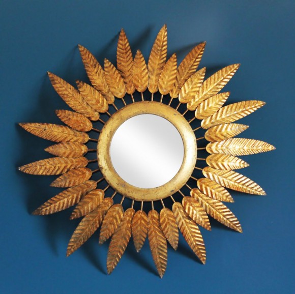 Espejo sol en forja dorada, con diseño de hojas o plumas. Vintage años 60.