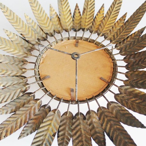 Espejo sol en forja dorada, con diseño de hojas o plumas. Vintage años 60.